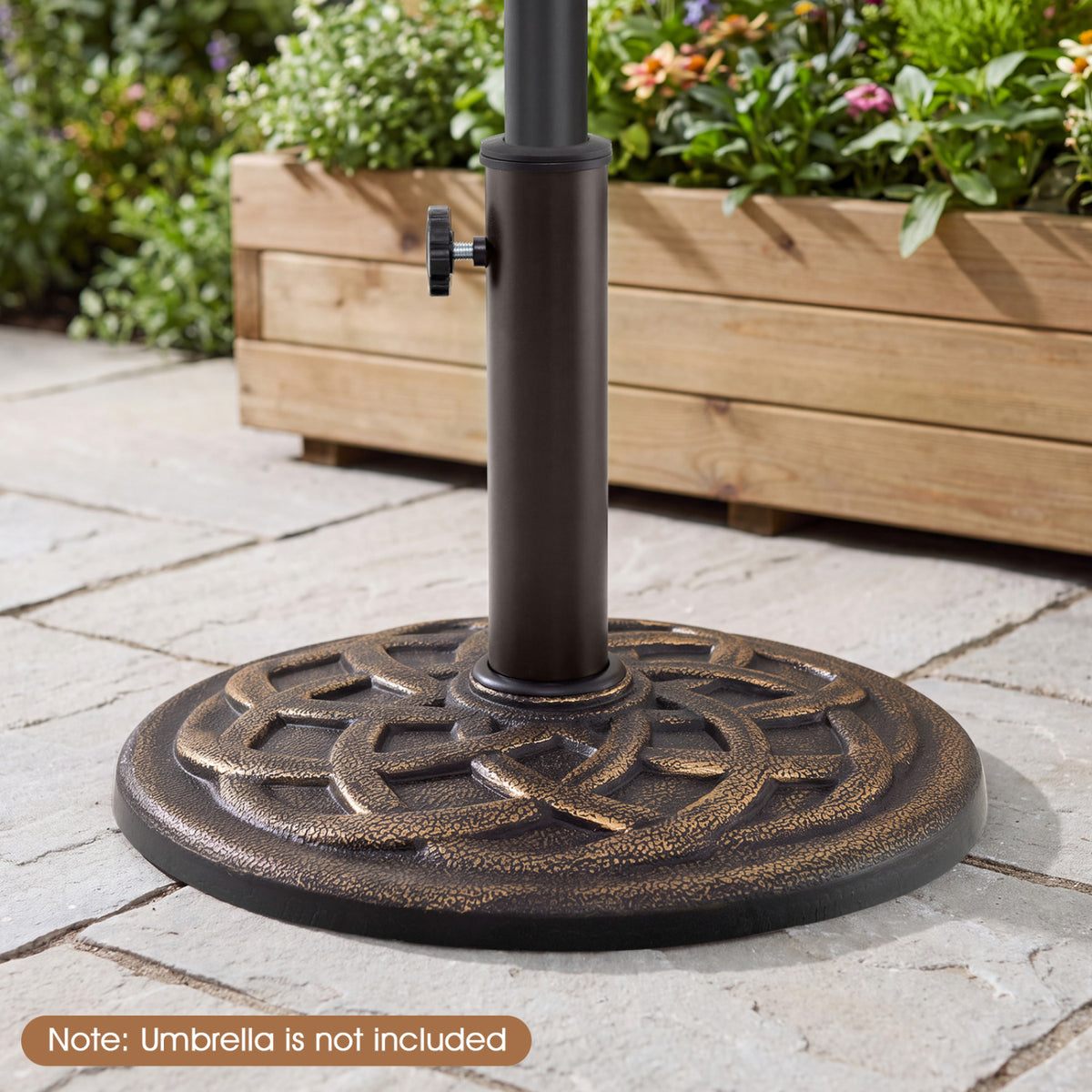 Close view of a textured round umbrella base and pole on a stone patio beside a wooden planter.