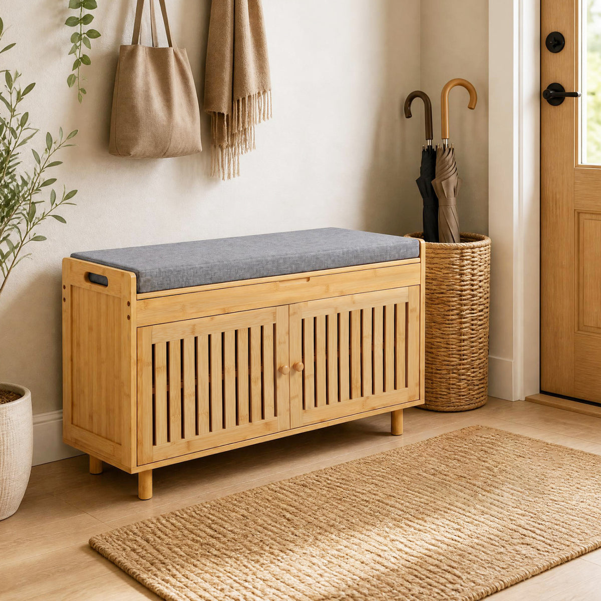 Natural bamboo shoe bench with gray cushion and slatted doors in a warm entryway.