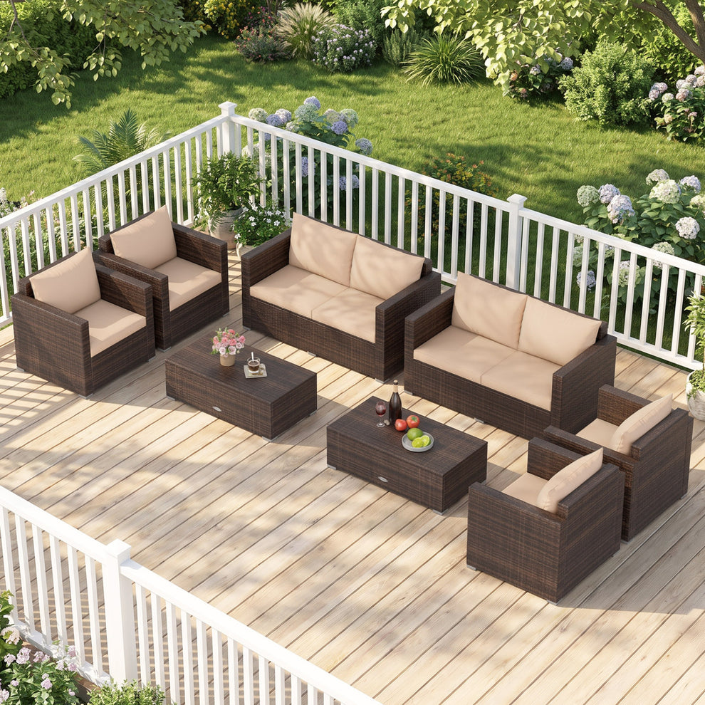 Dark woven rattan seating and two coffee tables arranged on a garden deck