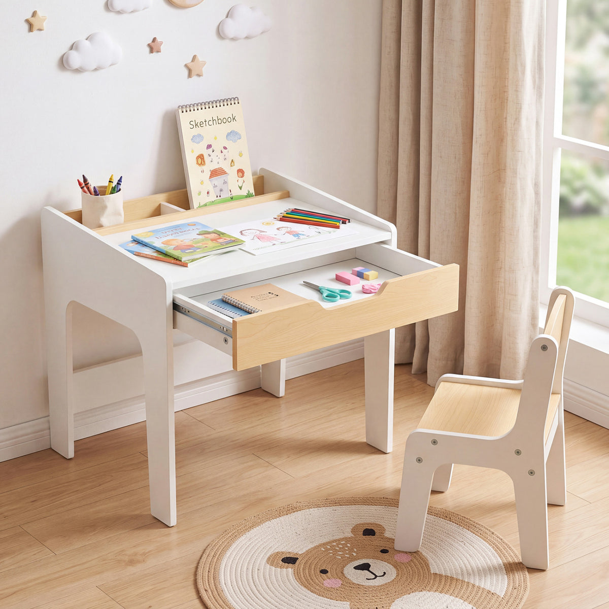 White and natural wood desk with an open drawer and matching chair in a bright children’s room.