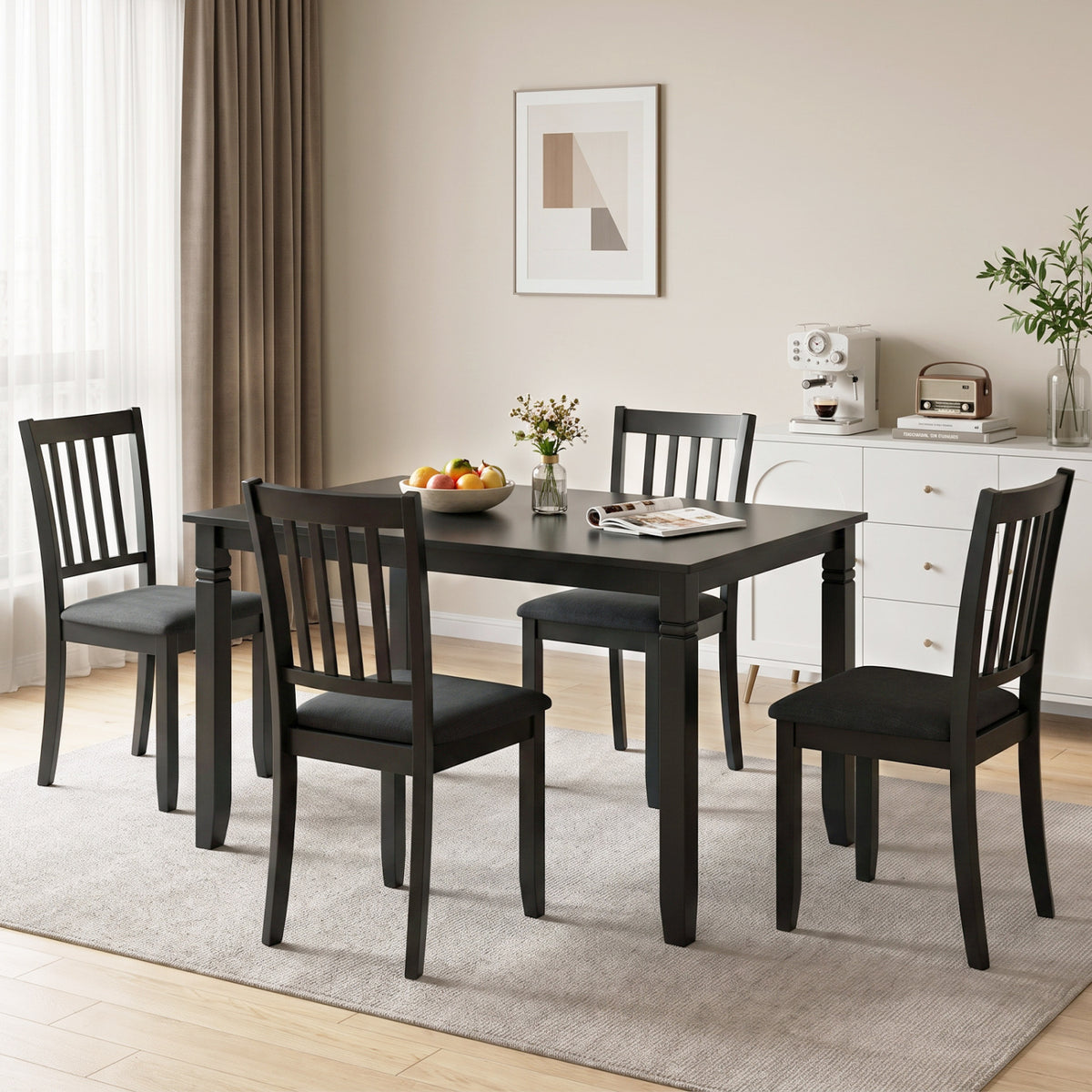 Black rectangular table surrounded by four dark slat-back chairs in a bright dining room.