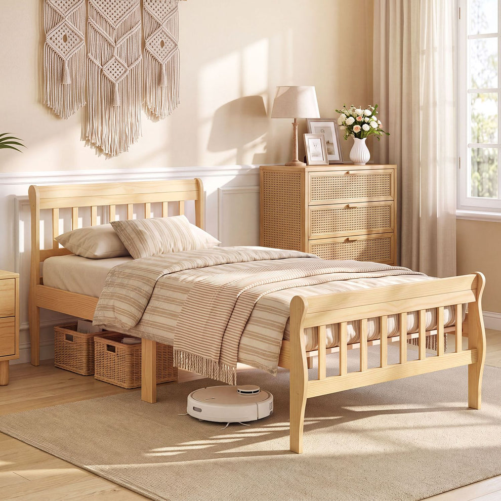 Light wood bed with slatted headboard and footboard dressed in striped bedding in a bright bedroom.