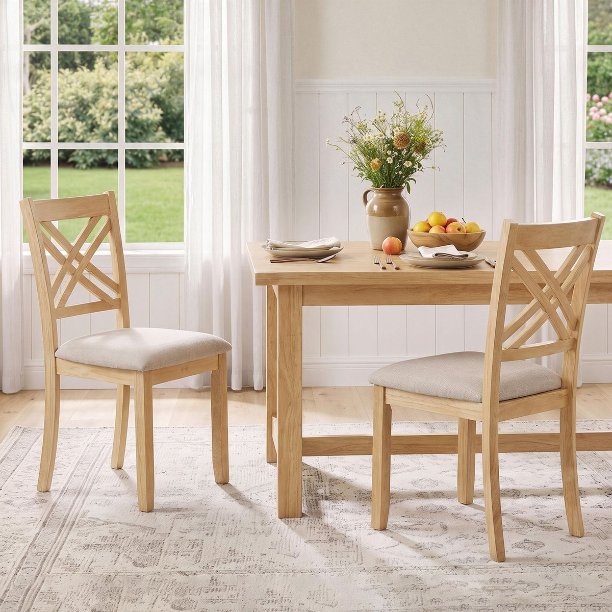 Two light wood chairs with pale upholstered seats arranged around a dining table by a window.