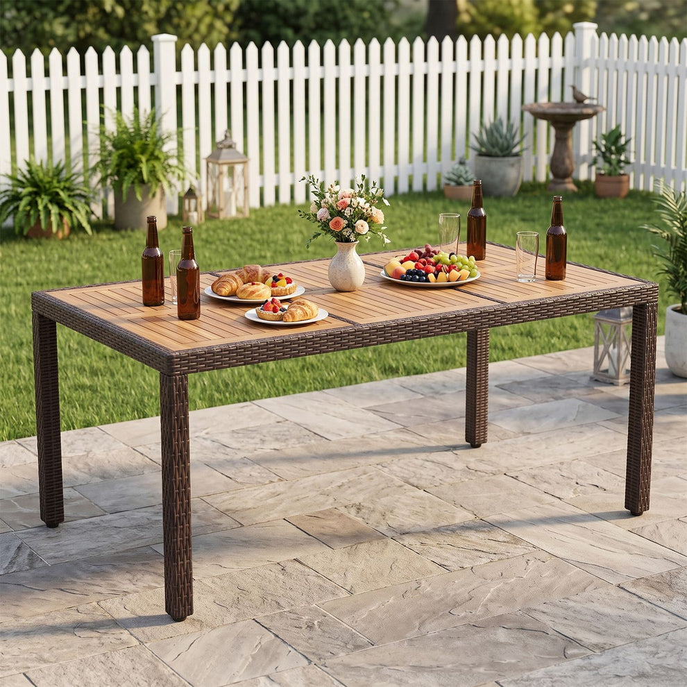 Rectangular slatted patio dining table set with food and drinks on a stone terrace.