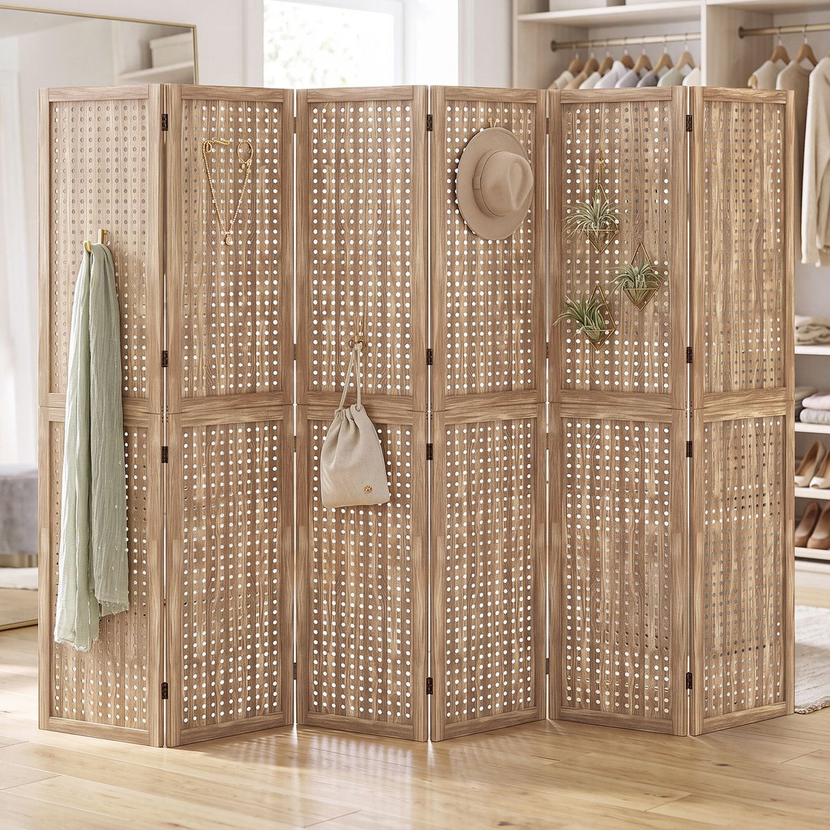 Six-panel wooden pegboard divider displayed in a dressing room with clothing and accessories hanging from it.