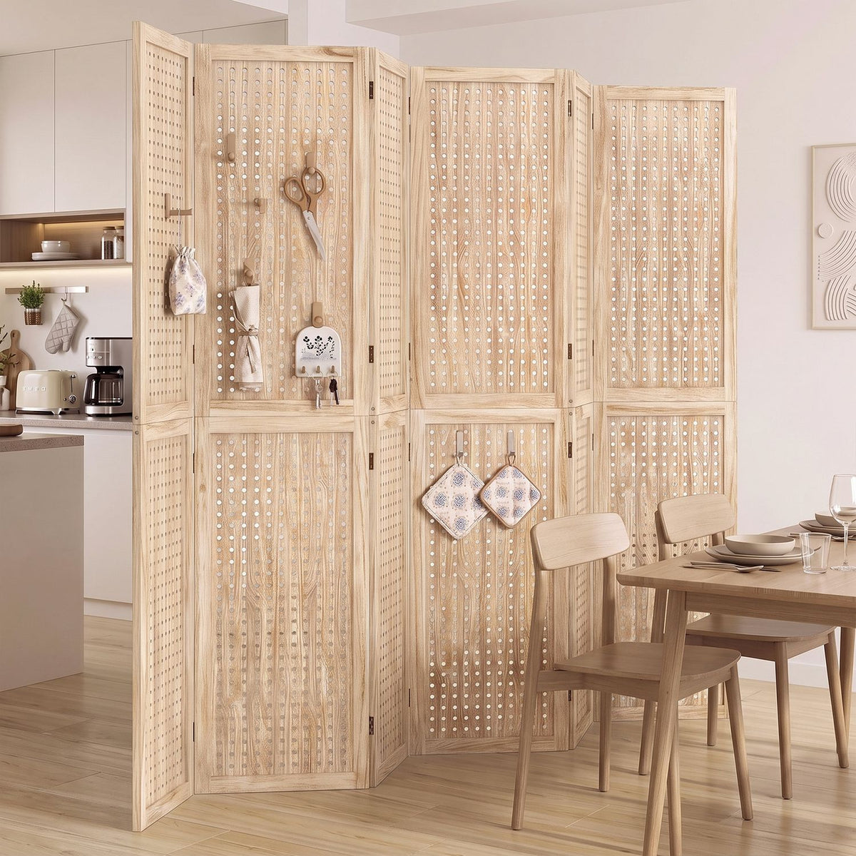 Perforated wooden folding divider separates a kitchen from a dining area, with small items hanging from its panels.