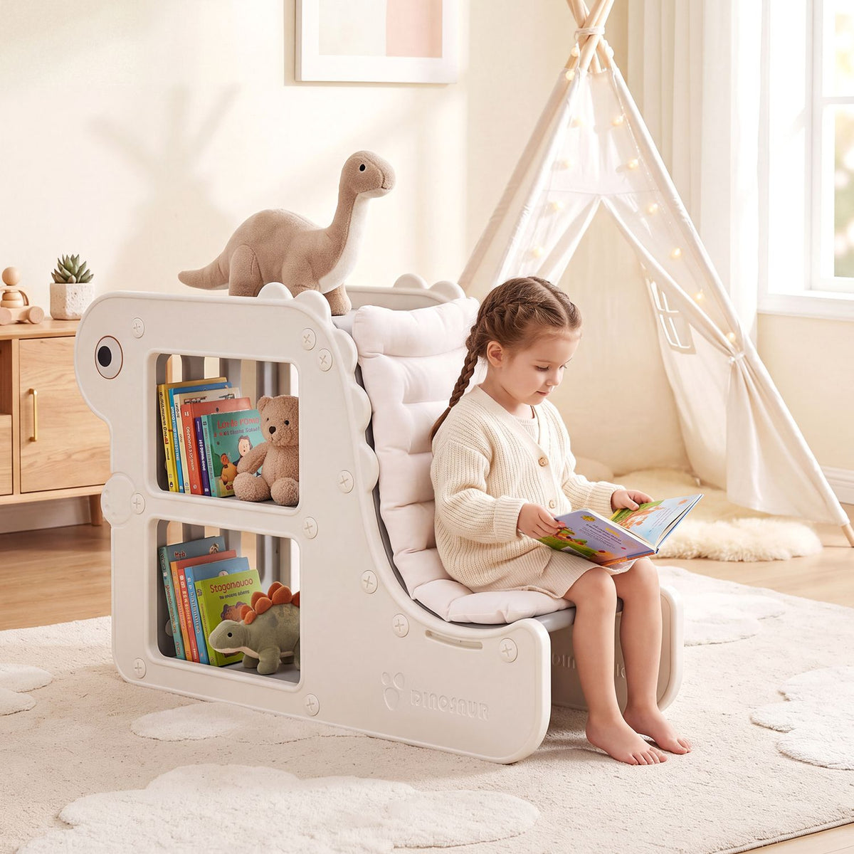 A child reads while seated on a white cushioned bookshelf with open book cubbies in a bright playroom.