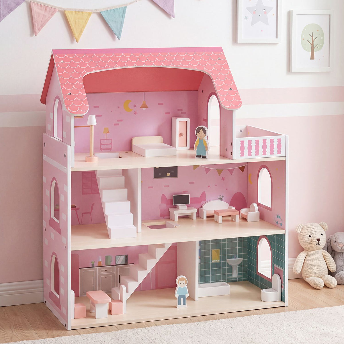 Front view of a pink dollhouse with furnished rooms, displayed against a pale wall.