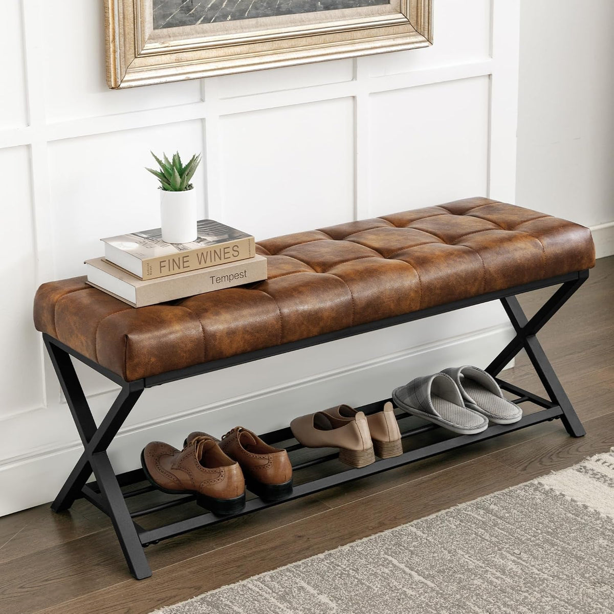 Brown tufted faux-leather bench with X metal legs and a lower shoe shelf, angled front view