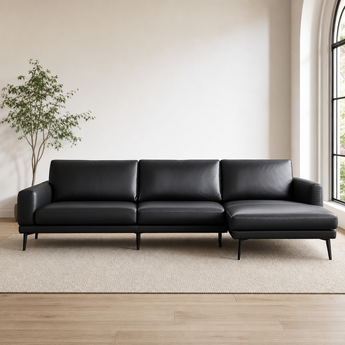 Three-piece framed abstract canvas set in black and white above a black leather sofa, front view in a living room