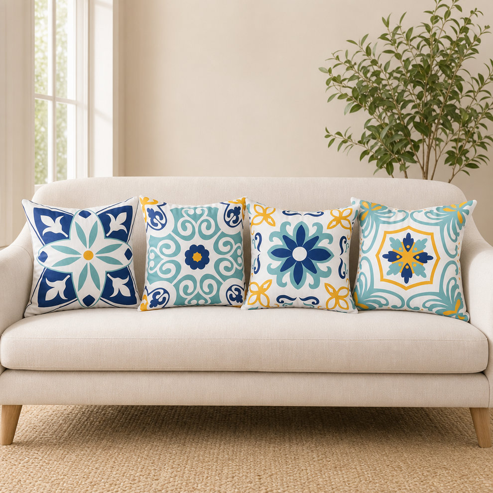 Beige sofa with four boho floral patterned square pillow covers in blue, teal and yellow tones, front view