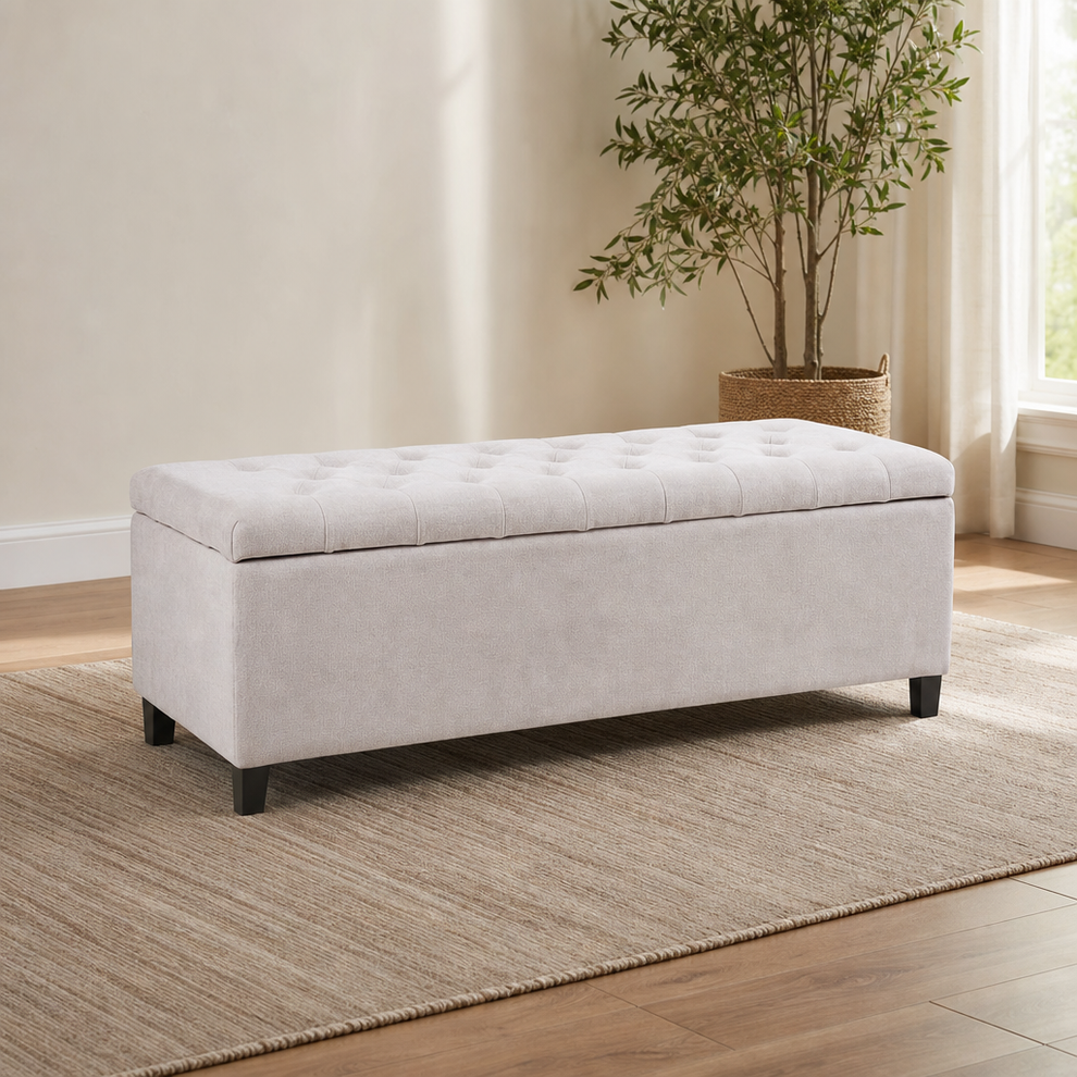 Light fabric upholstered storage bench angled front view with birch legs in a bright room