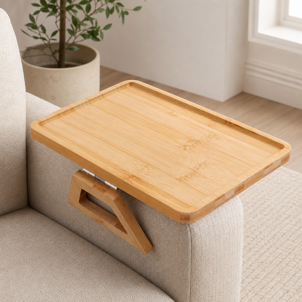 Bamboo folding sofa arm tray set across a beige sofa arm showing hinge and tray surface from an angled front view