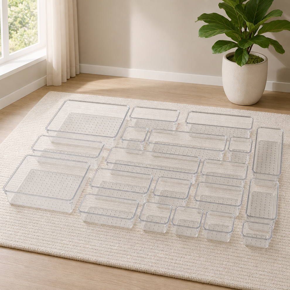 Clear plastic drawer organizer trays arranged on a light rug showing the full multi-piece set layout