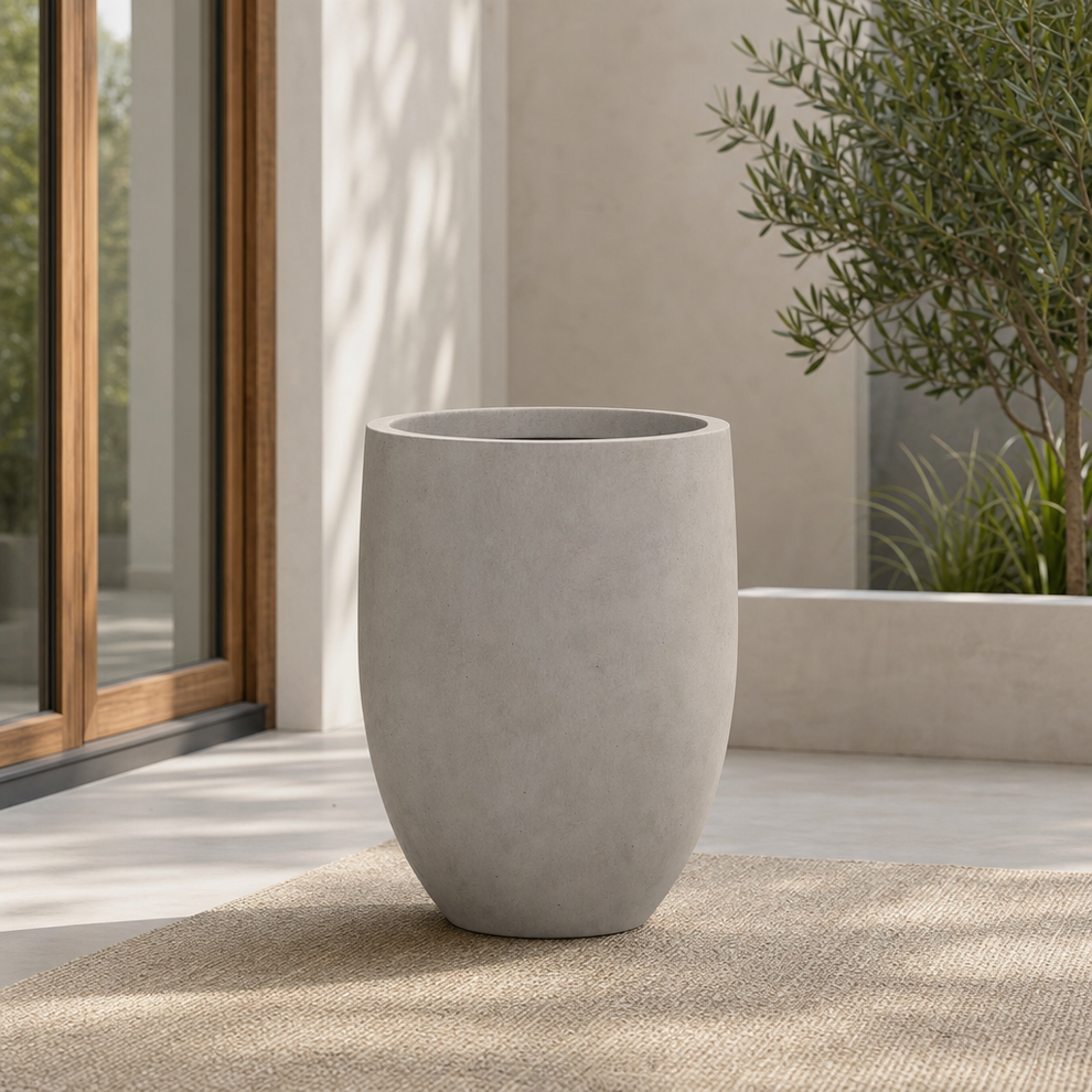 Kante 21.7" H Modern Tall Round Concrete Planter for Indoor/Outdoor Use centered in a warm neutral furnished room