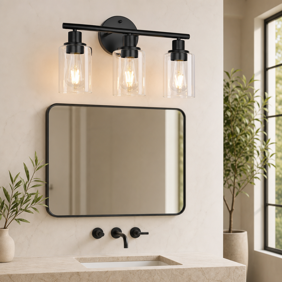 Black three-light vanity fixture with clear cylindrical glass shades above a bathroom mirror, angled front view