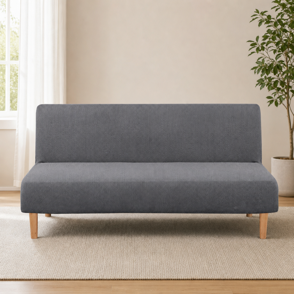 Grey textured small-check jacquard futon slipcover front view on wooden-legged sofa in a neutral living room