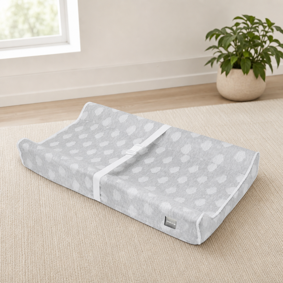 Jool Baby Soft Contoured Changing Pad with Washable Cover centered in a warm neutral furnished room