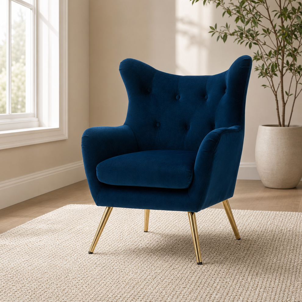 Navy velvet wingback accent chair front three-quarter view with gold-tone tapered legs on a light rug in a living room
