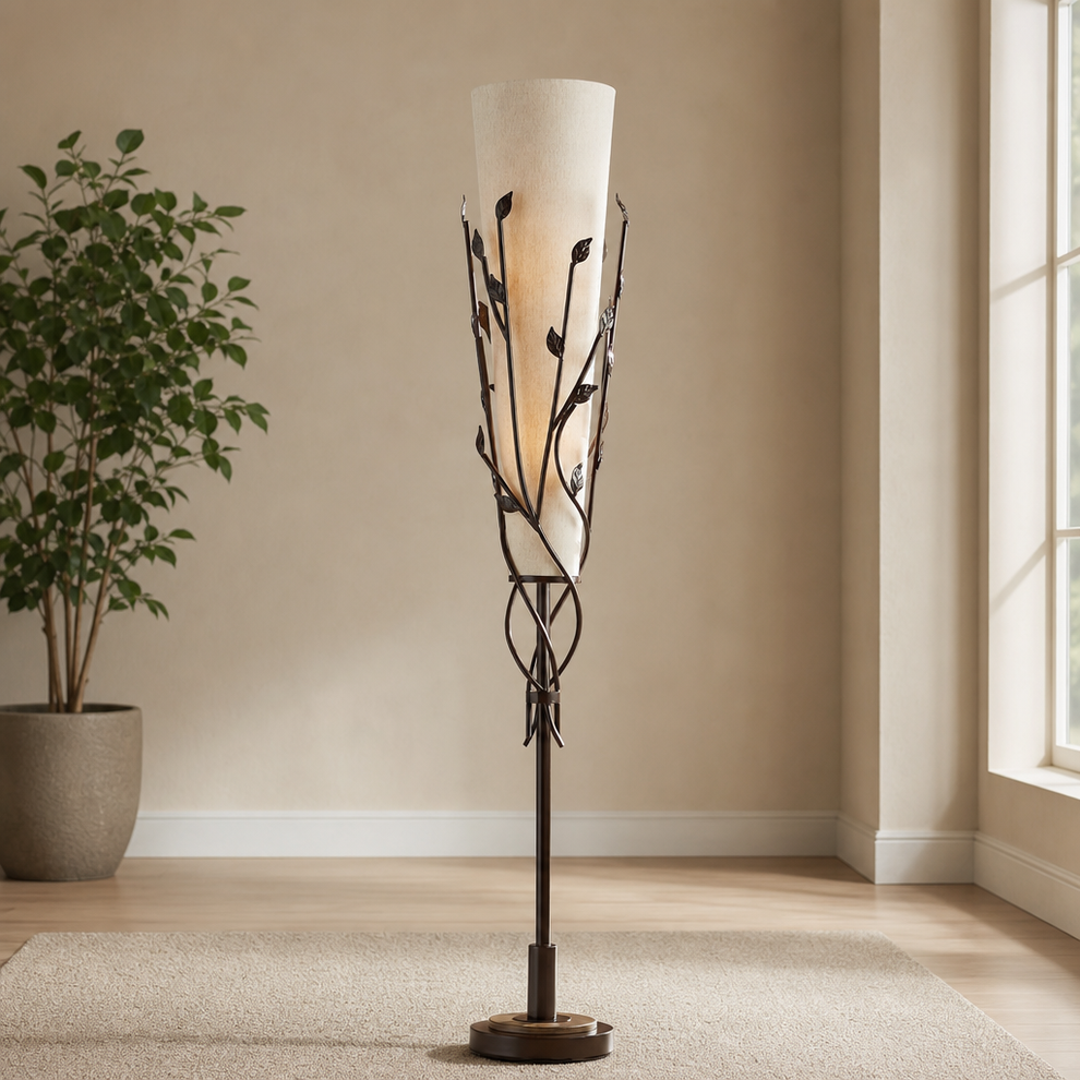 Bronze uplight floor lamp with tall tapered linen shade and vine motif, front view in a living room