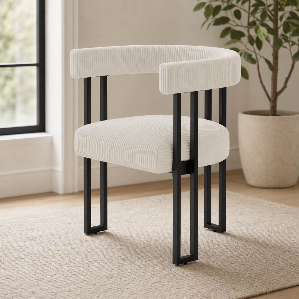 Cream boucle corduroy dining chair angled front-left view with black metal legs in a bright room