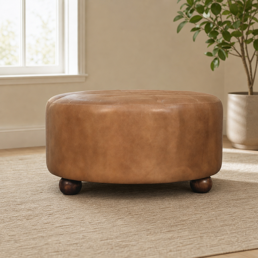 Brown Buffalo hide leather Round Ottoman centered in a warm neutral furnished room