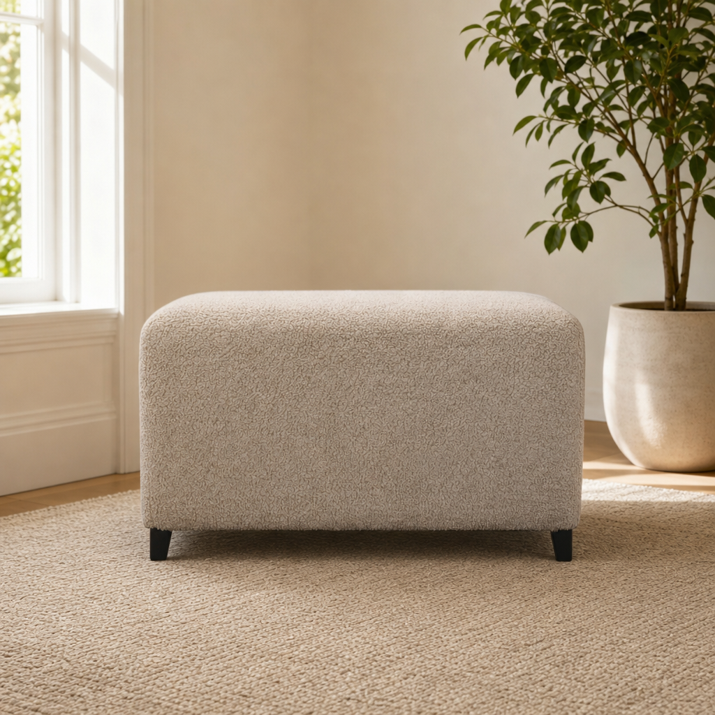 Bliss Cream Bouclé Ottoman centered in a warm neutral furnished room