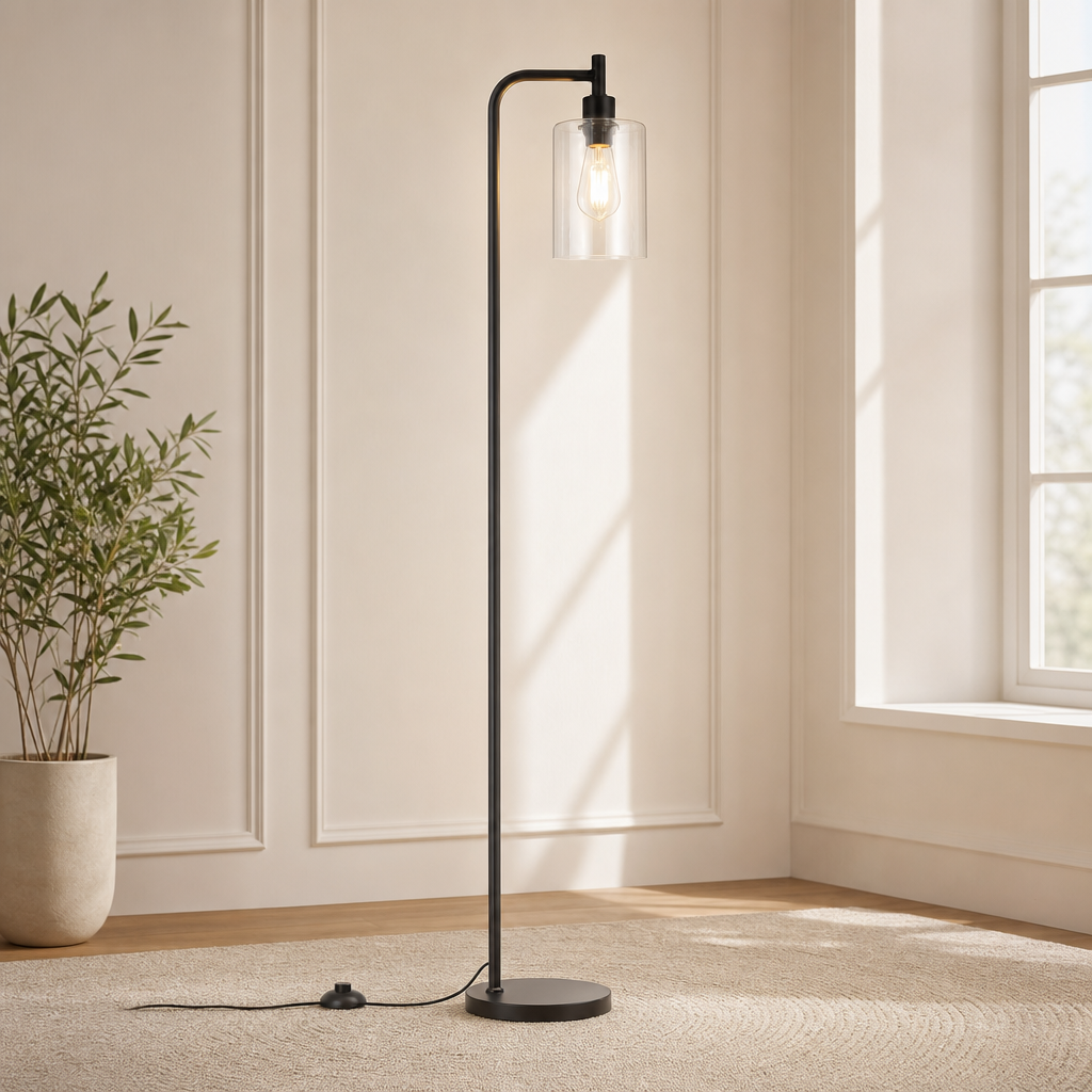 Clear glass shade floor lamp in black, full-height front view showing round base and cord foot switch in a living space