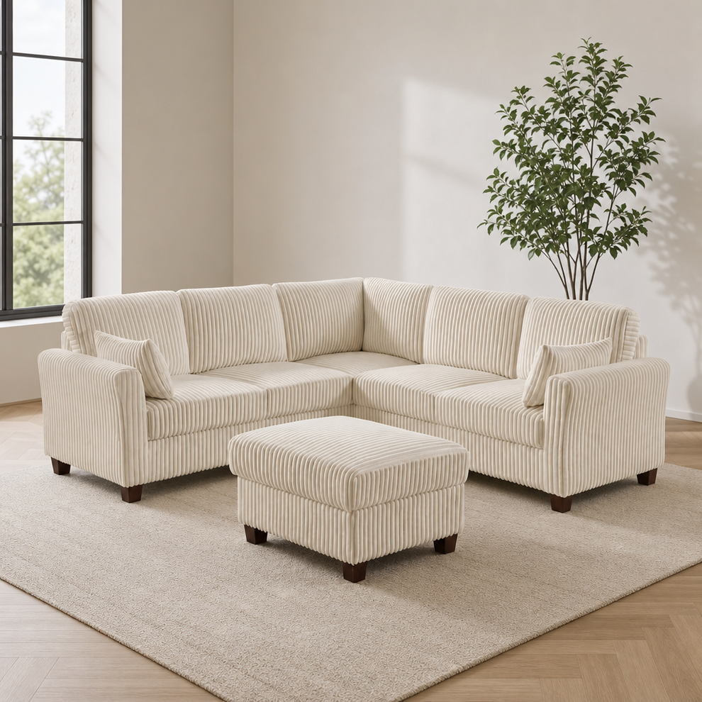 Cream corduroy L-shaped corner sectional with matching storage ottoman, angled front view in a bright room