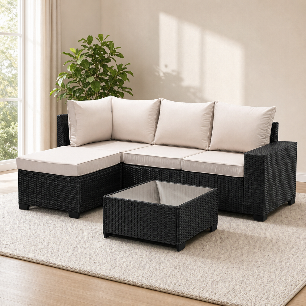 Beige‑cushioned PE rattan corner sectional with tempered glass coffee table, angled front view on a light rug.