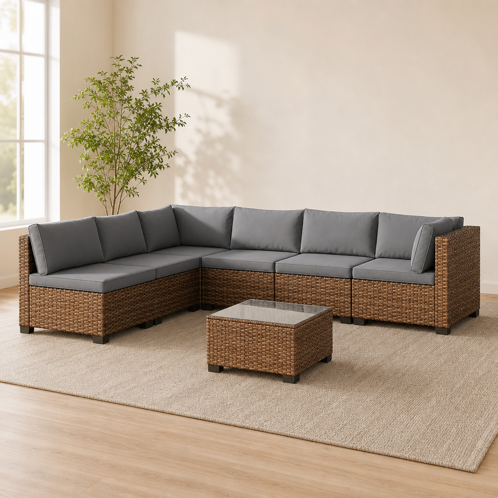 Brown PE rattan 7-piece sectional with grey cushions shown angled front on a neutral rug in a bright room