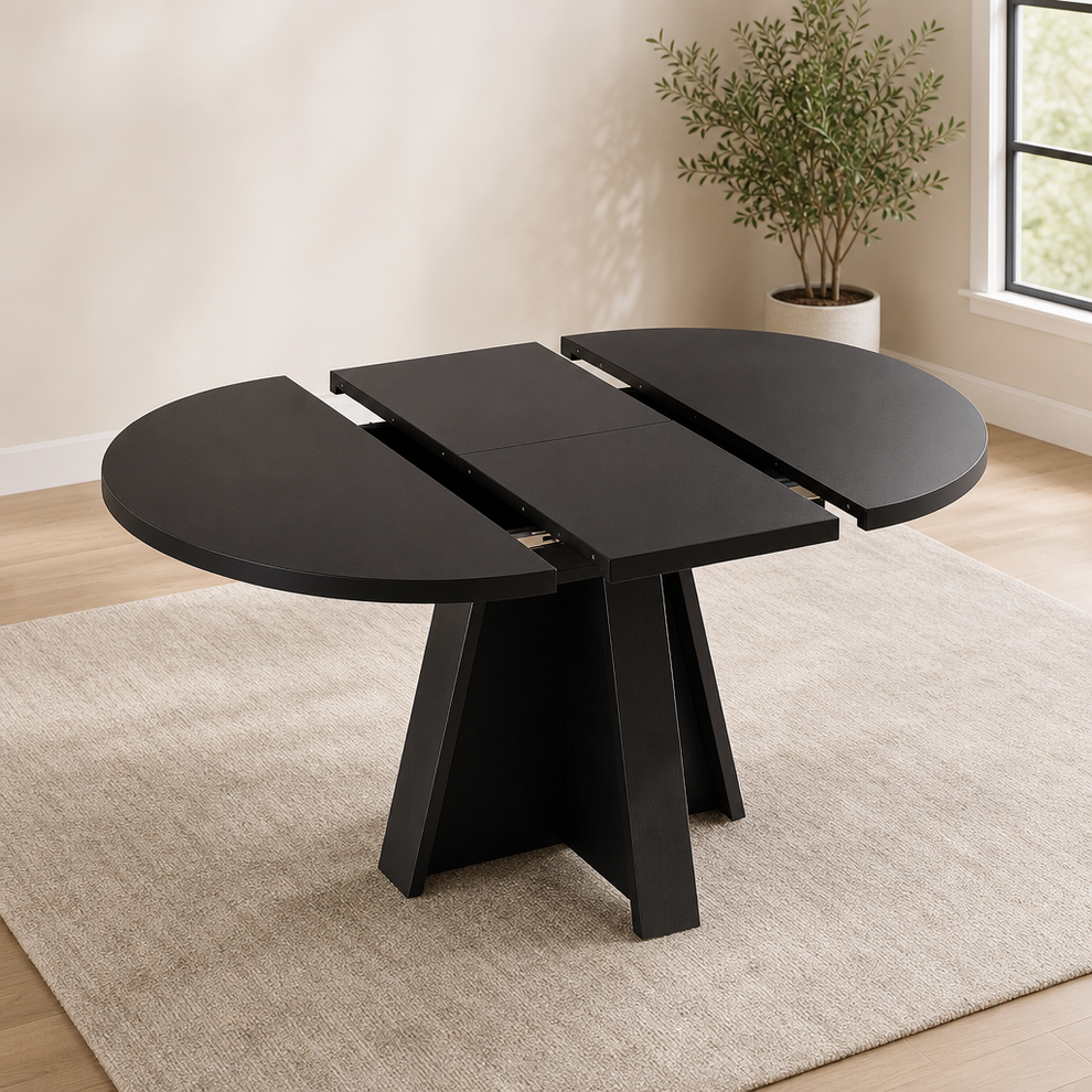 Black extendable dining table partially extended showing three-panel top and figure-eight pedestal base