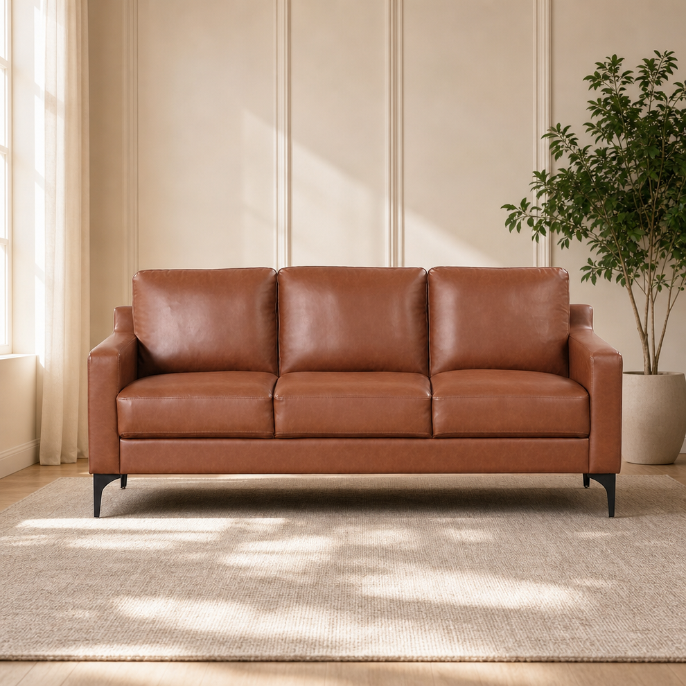 Brown faux-leather 3-seat sofa front view with channel-tufted arms in a sunlit living room