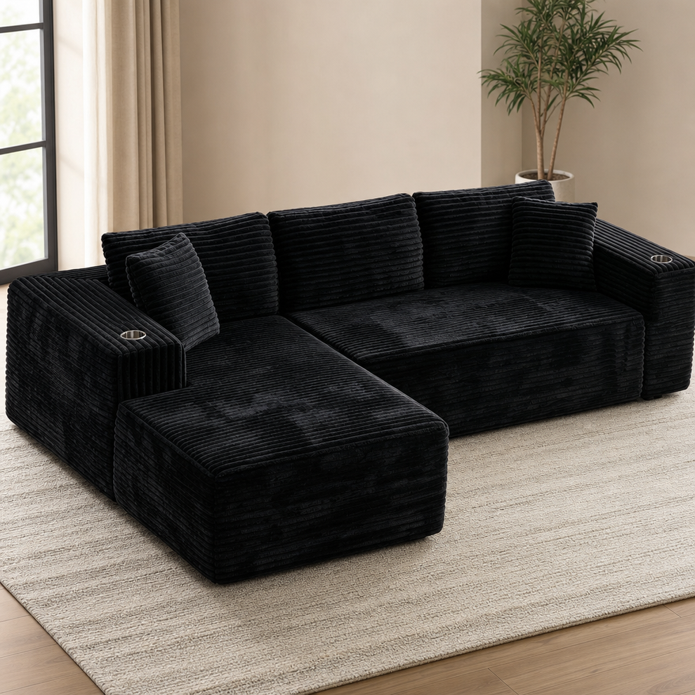 Black corduroy modular sectional with oversized chaise, left-facing view on a light rug in a neutral living room
