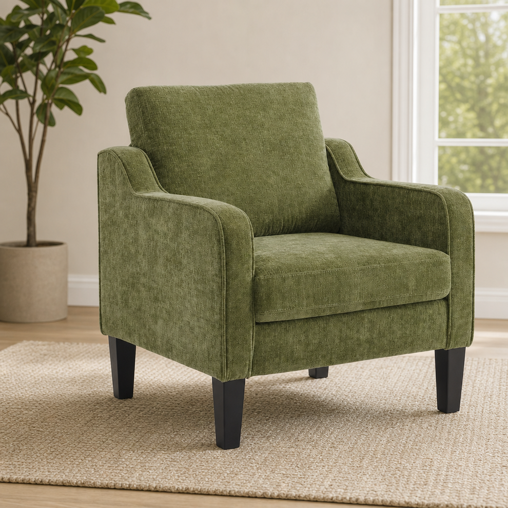 Green upholstered accent chair angled front-left with tapered dark wood legs and potted plant by a window