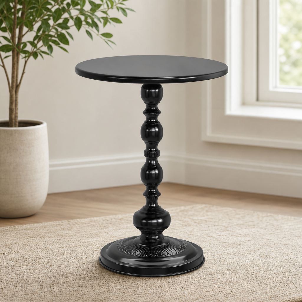 Black round metal side table angled front view showing turned pedestal and circular tabletop on a rug