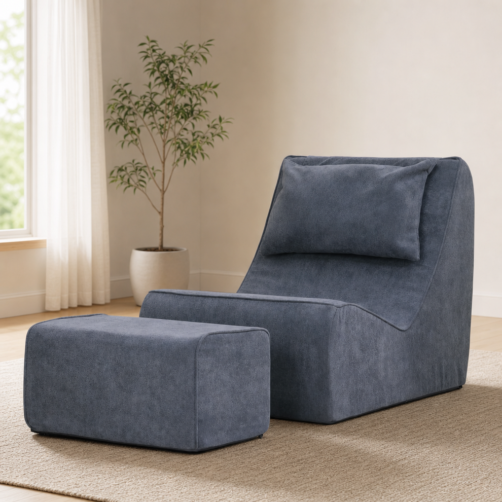 Dark blue-gray snow-velvet chaise lounge with matching ottoman, angled front view on a rug