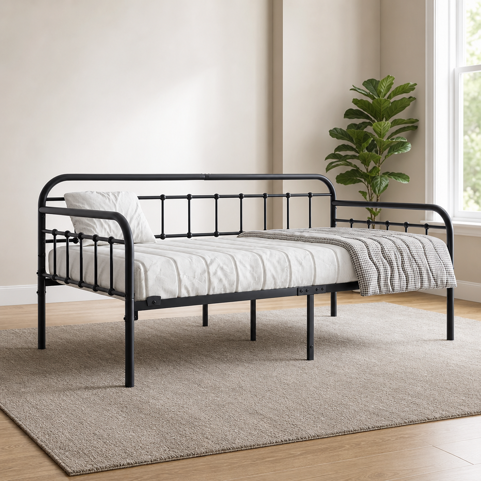 Black metal twin daybed angled front view showing Victorian-style rails and platform slat base on a neutral rug