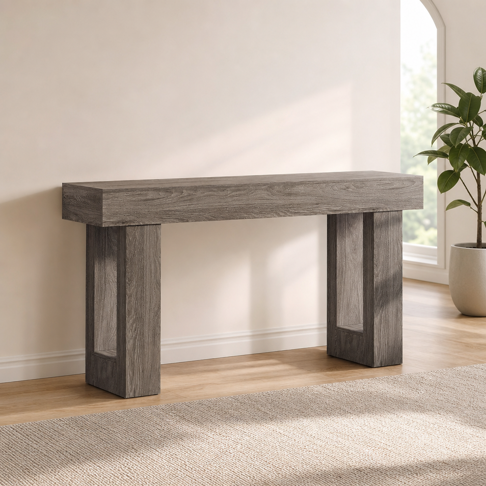 Grey farmhouse console table front-left angled view against a pale wall with a potted plant