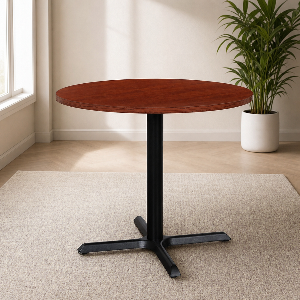 Round cherry laminate-top 36-inch table with black cast-iron X-base, angled front view in a bright room