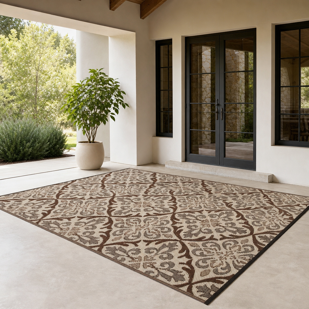 Brown and cream patterned outdoor rug on a covered patio front-angle showing full rug and doorway