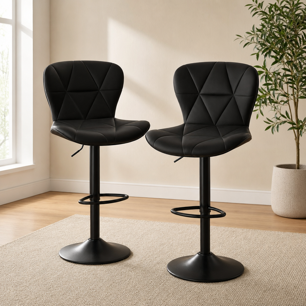 Two black faux leather counter-height swivel bar stools shown angled front view in a bright room