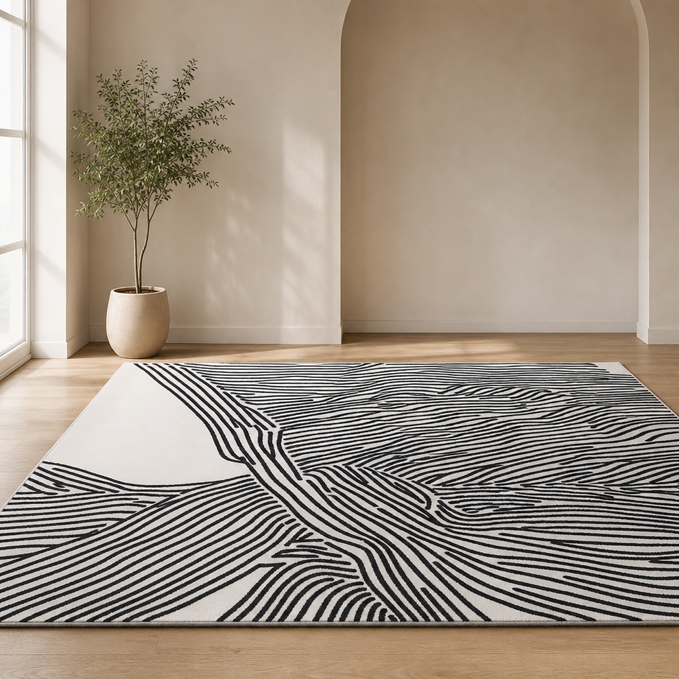 Beige rug with black abstract linear pattern angled front view on light wood floor in a bright neutral room