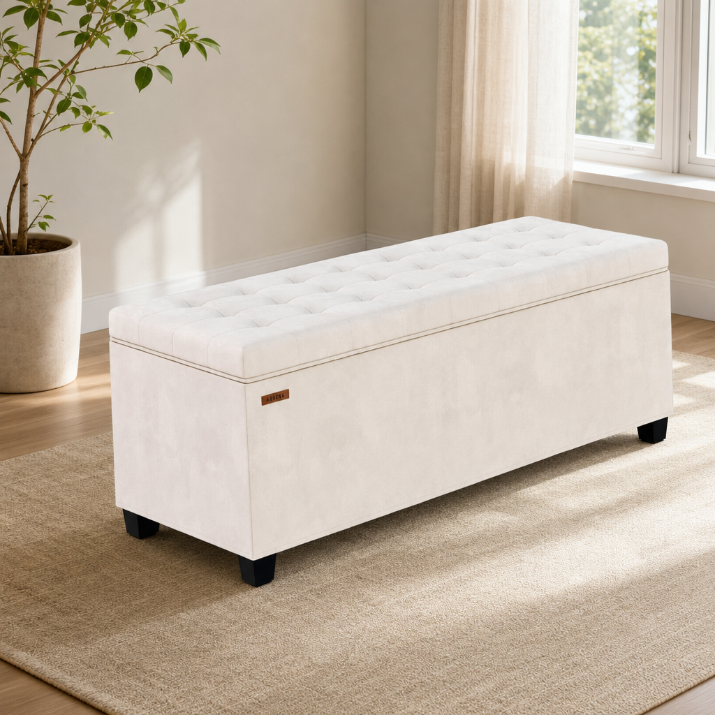 White tufted storage bench with black block legs angled front view in a sunlit living room