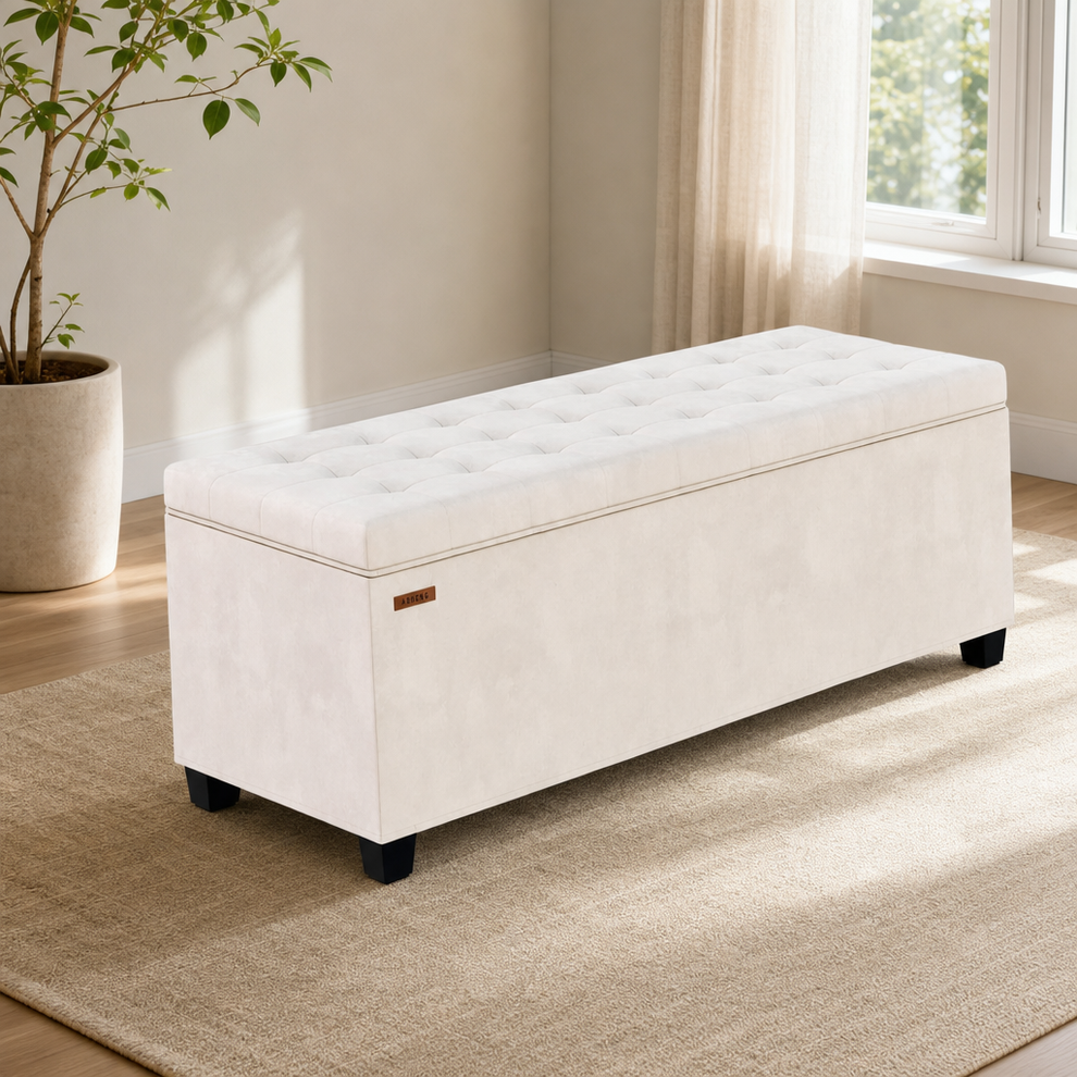 White tufted storage bench with black block legs angled front view in a sunlit living room