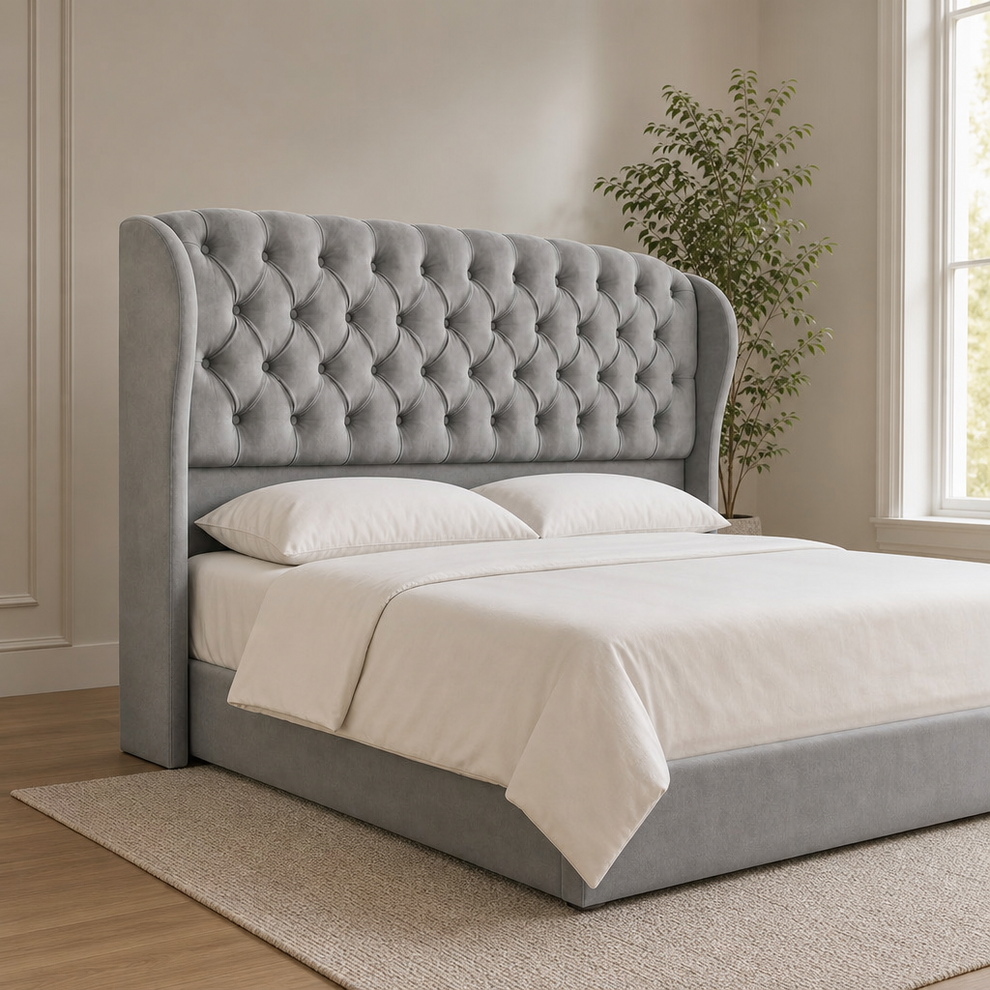 Gray velvet tufted wingback headboard on full bed, angled front-left view in a neutral bedroom