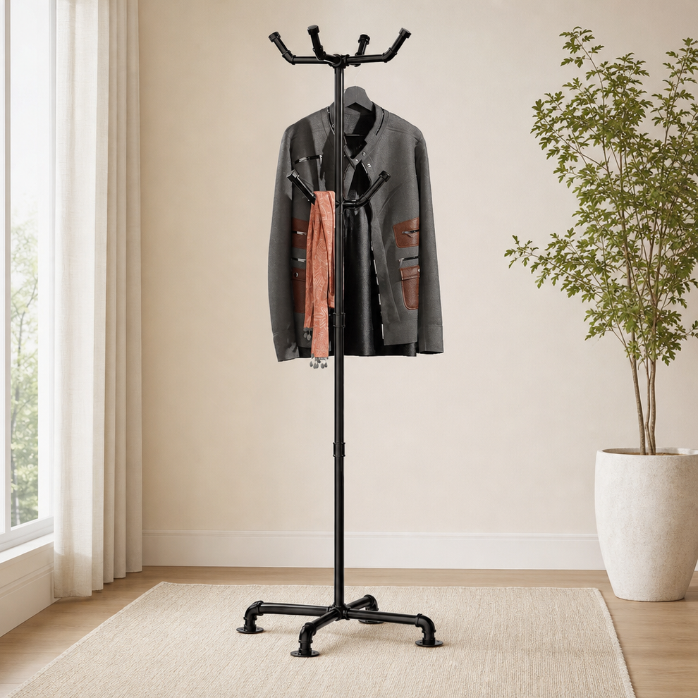 Black metal pipe coat rack full-height in a bright entryway with a rug and a potted plant