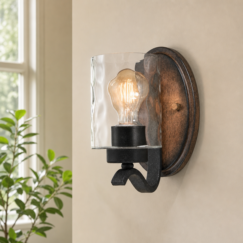 One-Light Wall Sconce with Textured Iron Arm, Wood-Tone Back Plate & Clear Hammere centered in a warm neutral furnished room