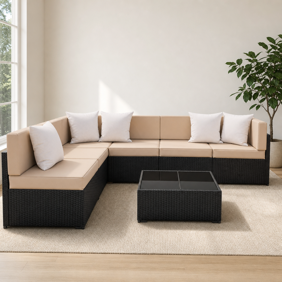 7-Piece Outdoor PE Rattan Sectional Sofa Set with Glass-Top Coffee Table, Modular centered in a warm neutral furnished room