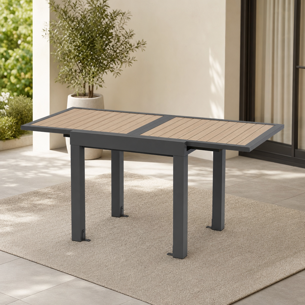 31.5–63 in Aluminum Extendable Patio Table, Seats 4–6 centered in a warm neutral furnished room